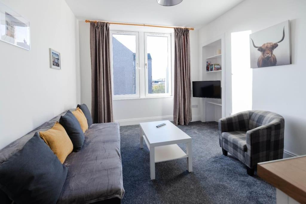 a living room with a couch and a chair at Helensburgh Holiday Apartment in Helensburgh