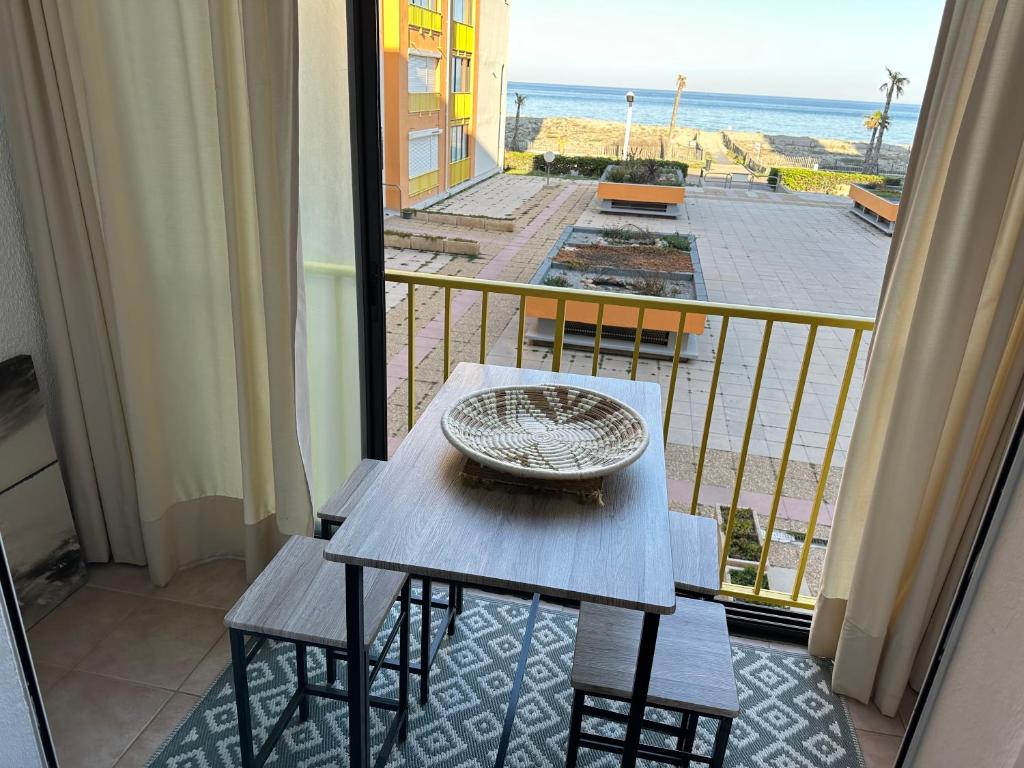 a table and chairs on a balcony with a view of the ocean at Appartement vue mer in Le Barcarès