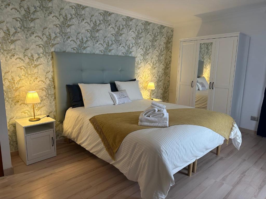 a bedroom with a large bed with floral wallpaper at Lujoso y céntrico vistas al mar in Santa Cruz de Tenerife