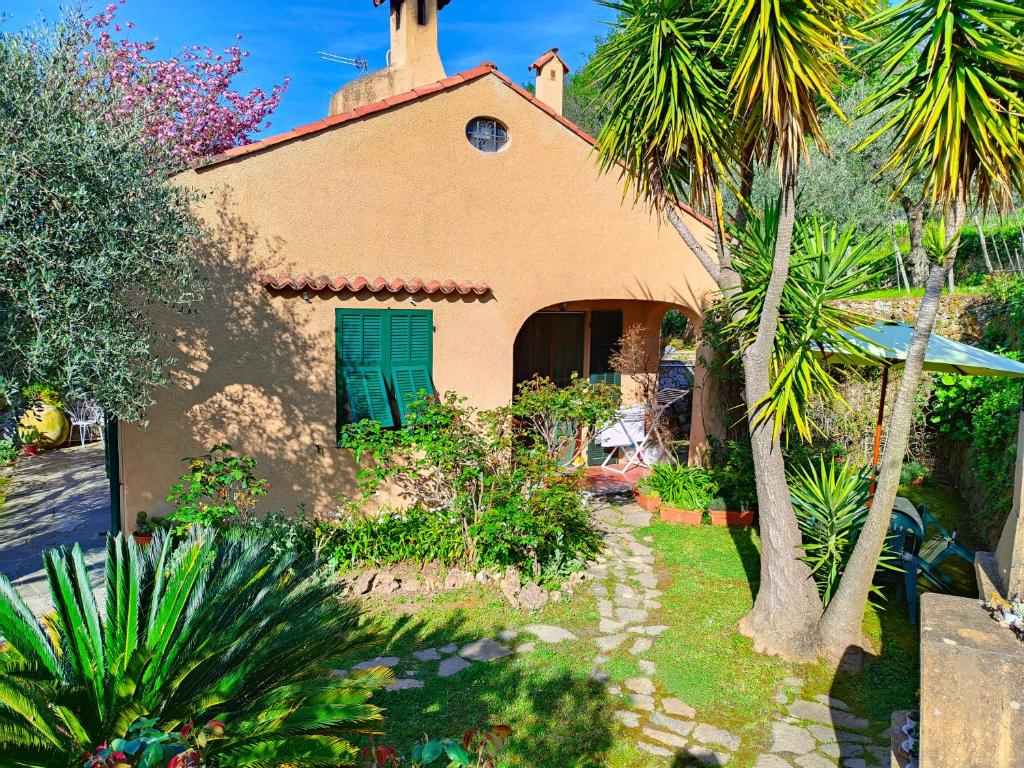 uma casa com uma porta verde e algumas palmeiras em L'Uliveto D'Argento em Finale Ligure