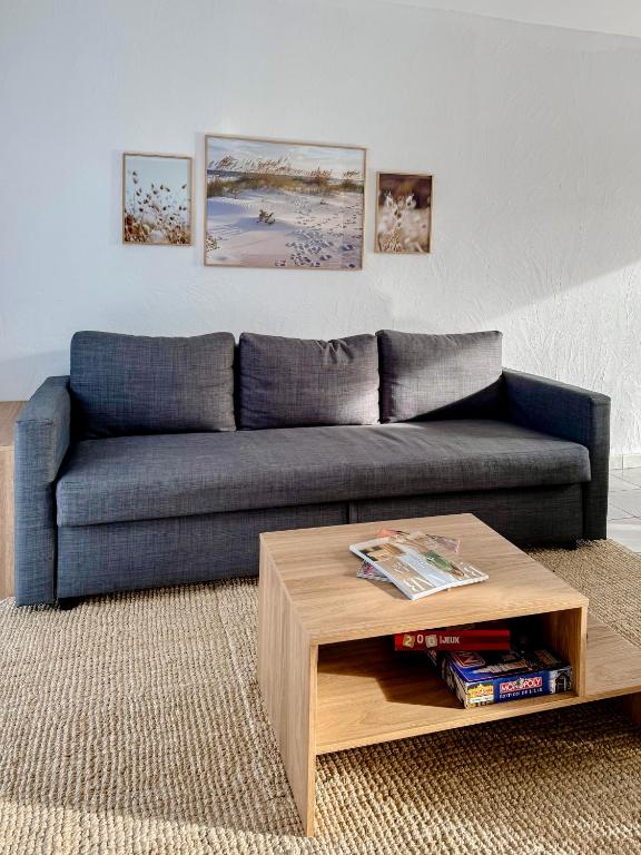 a blue couch in a living room with a coffee table at Charmante maison familiale in Ouistreham