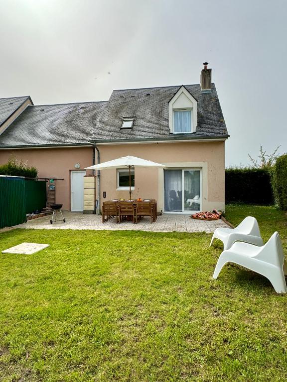 a house with a backyard with a table and chairs at Charmante maison familiale in Ouistreham