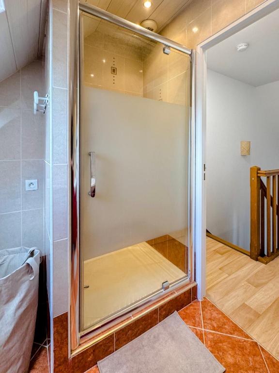 a shower in a room with a glass door at Charmante maison familiale in Ouistreham