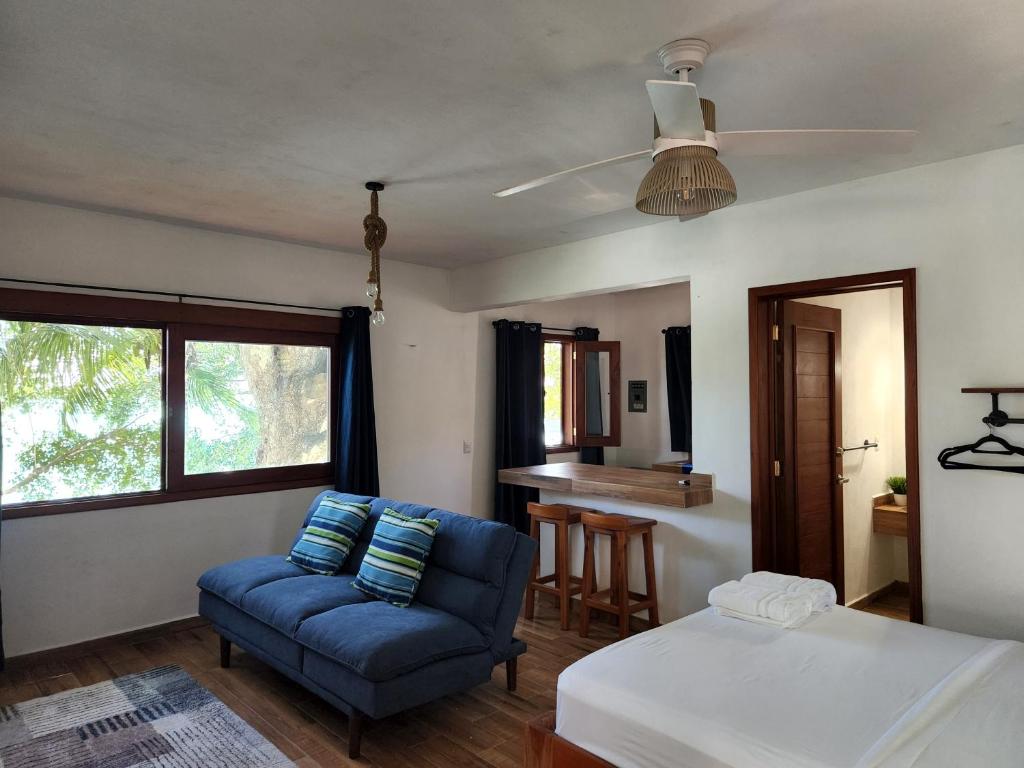 Huay PixにあるVILLAS MILAGROSのベッドと青いソファのある寝室