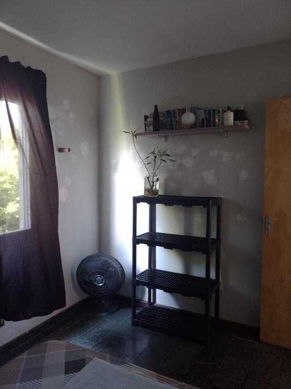 a room with a shelf with a plant on the wall at Quarto Aconchegante in Campos dos Goytacazes