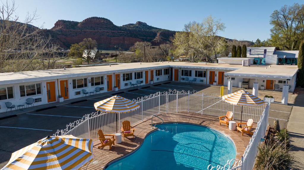 a hotel with a swimming pool and umbrellas at Quail Park Lodge in Kanab