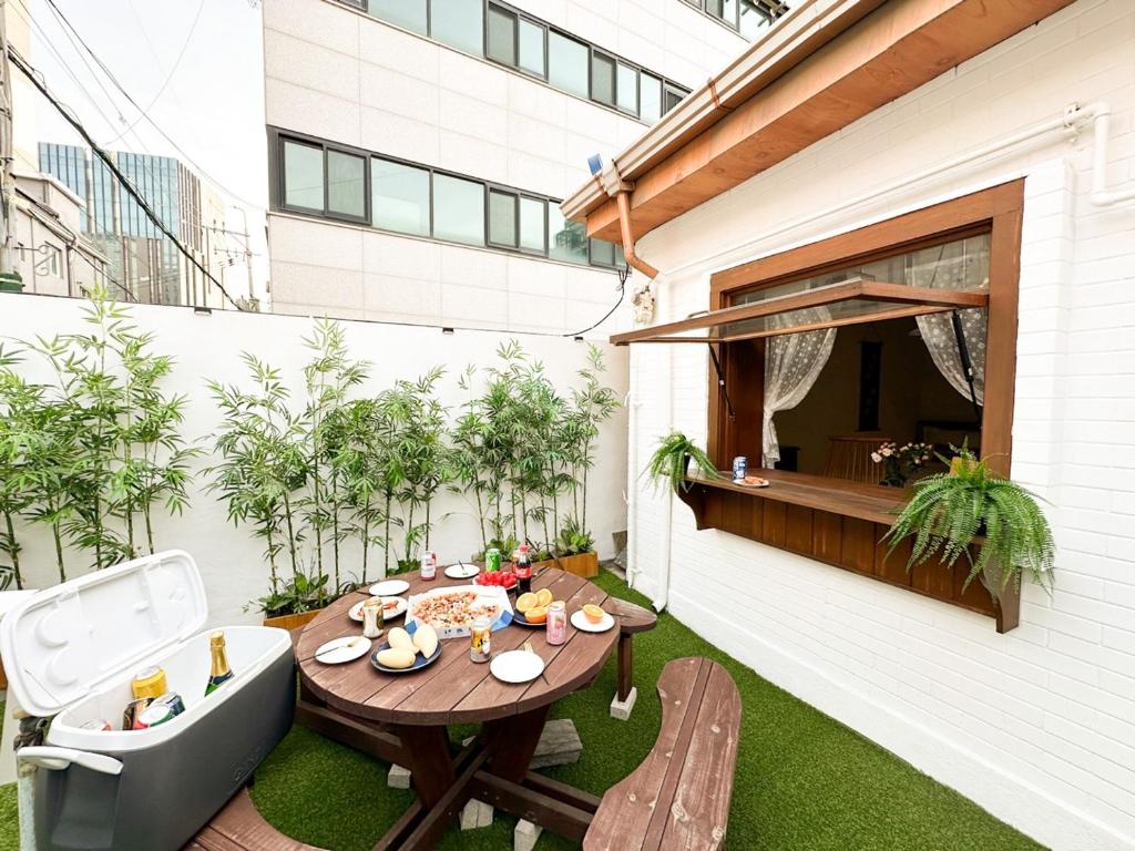 an outdoor patio with a wooden table and chairs at Yunseul- Garden House in the City with Korean Beauty in Seoul