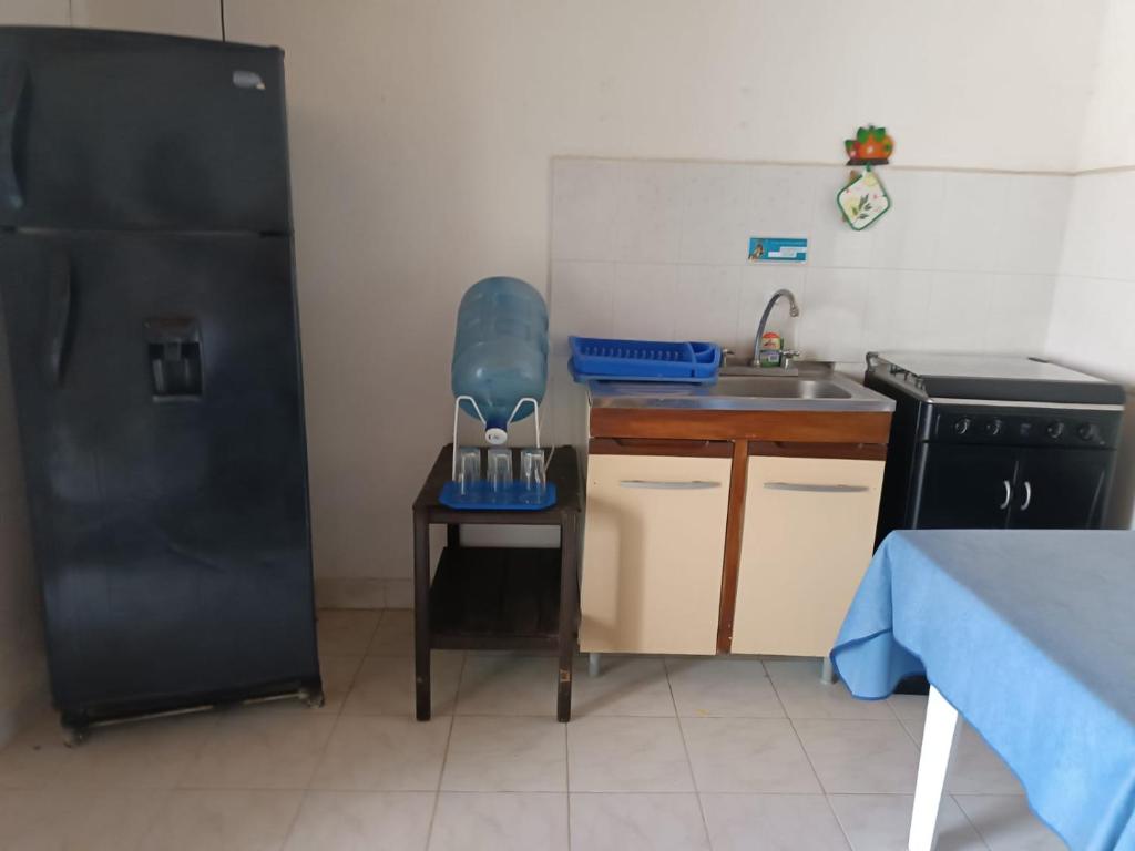 a small kitchen with a sink and a black refrigerator at Ortimar in Tolú