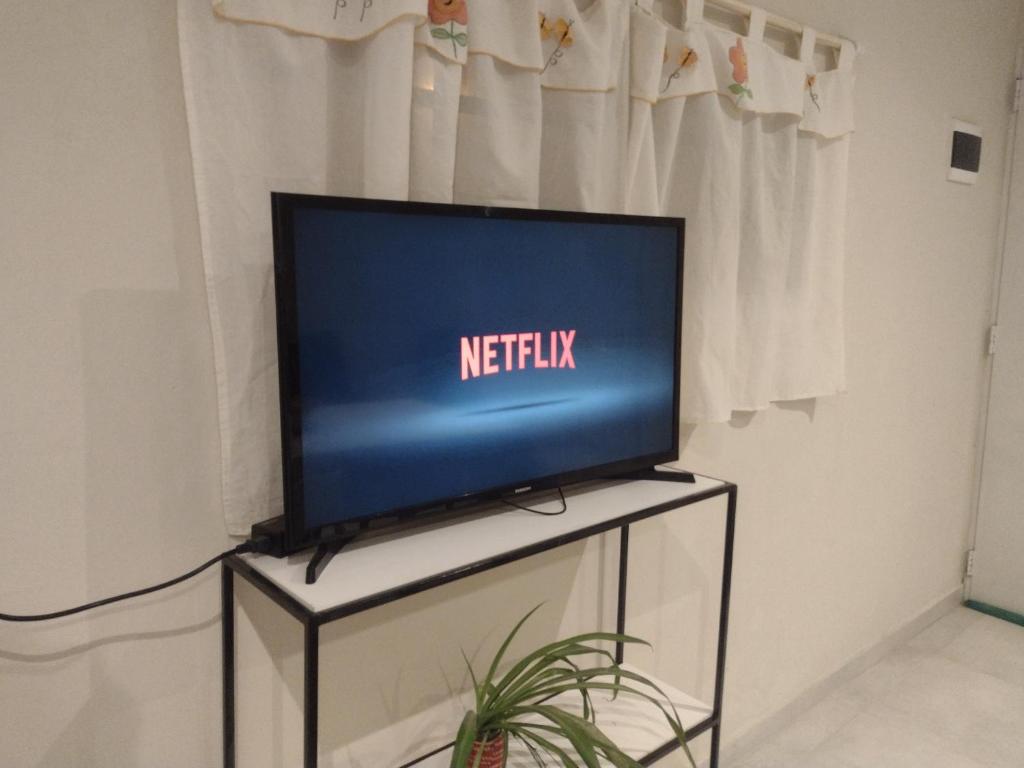 una TV a schermo piatto seduta sopra un tavolo di Apart Los Laureles a Villa Regina