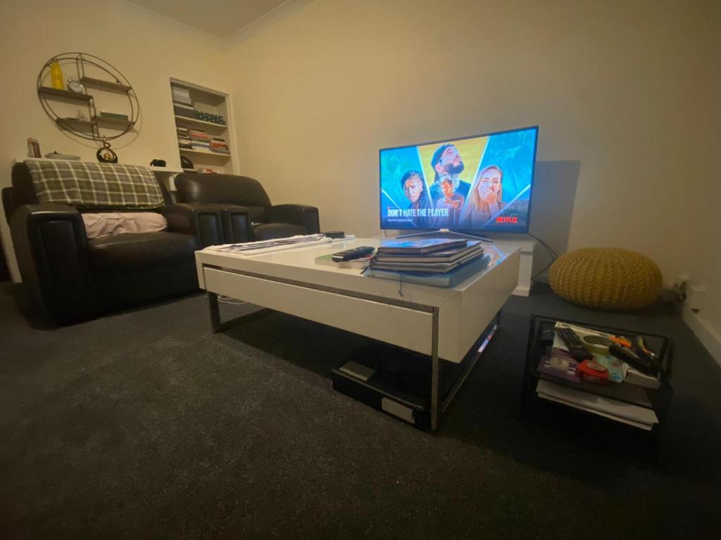a living room with a table with a laptop on it at Renton Residence in Renton