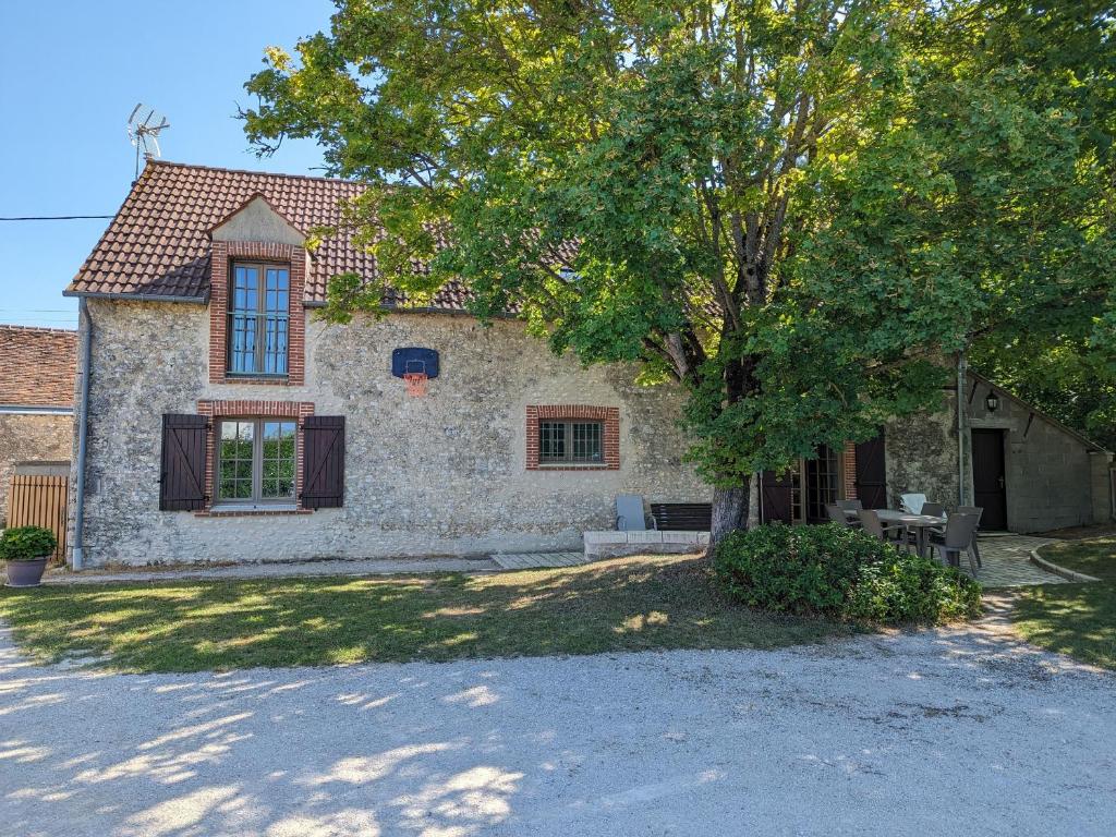 a stone house with a tree in front of it at Maison de campagne rénovée à 1h de Paris, avec jardin clos, 4 chambres et équipements familiaux - FR-1-590-164 in Treilles-en-Gâtinais
