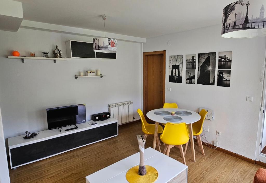 sala de estar con mesa y sillas amarillas en Nuevo Apartamento Vacacional en Cantabria, en Renedo de Piélagos