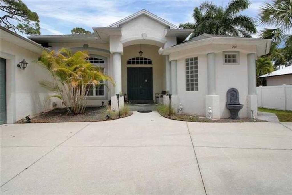 Uma casa branca com uma entrada à frente. em Mins To Florida White Sand Beach Villa Heated Pool em Nokomis