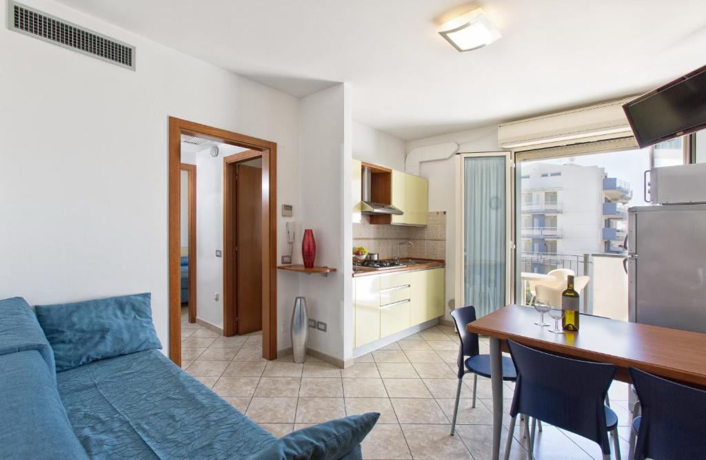 a living room with a blue couch and a kitchen at Residence il Girasole 1 in Alba Adriatica