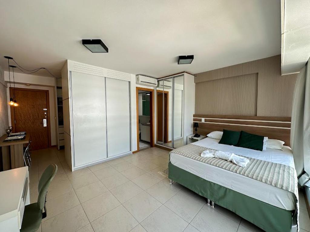 a bedroom with a bed and a desk in a room at Flat Saint Moritz Brasília Hotel in Brasilia