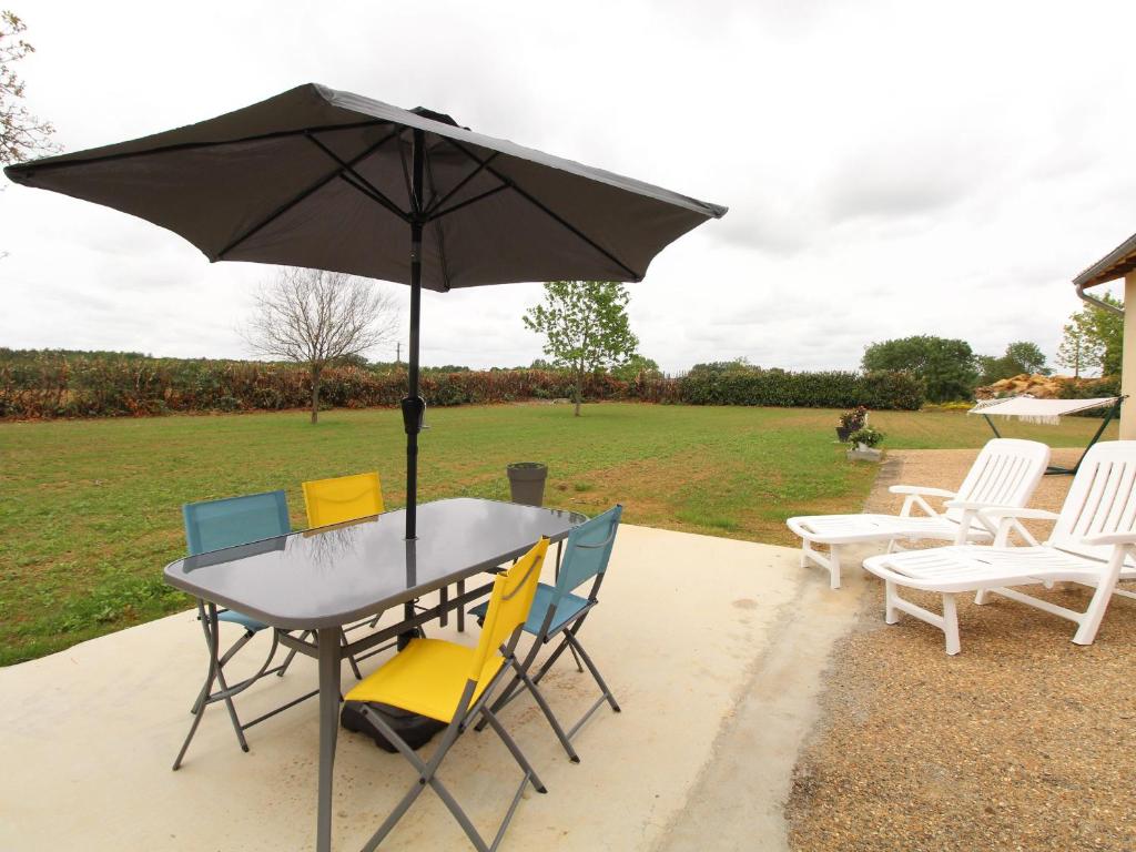 ein Tisch mit Stühlen und einem Sonnenschirm auf einer Terrasse in der Unterkunft Gîte de charme 4 pers avec spa privatif, terrasse, et équipements complets au cœur d'un village viticole - FR-1-622-20 in La Viardière