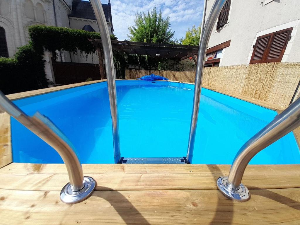 a blue swimming pool with two metal poles at Gîte Saint-Gaultier, 6 pièces, 12 personnes - FR-1-591-369 in Saint-Gaultier