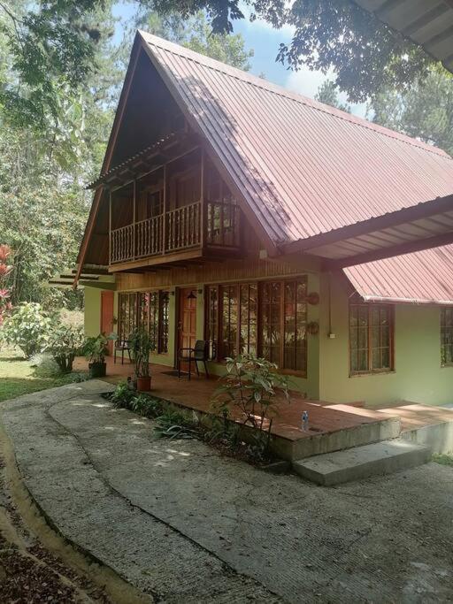 une petite maison avec un toit rouge et une terrasse couverte dans l'établissement Mountain Chalet, à Los Altos de Cerro Azul