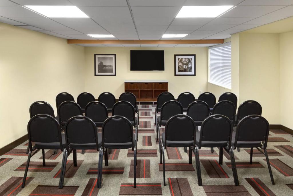 a conference room with black chairs and a flat screen tv at Four Points by Sheraton Surrey in Surrey