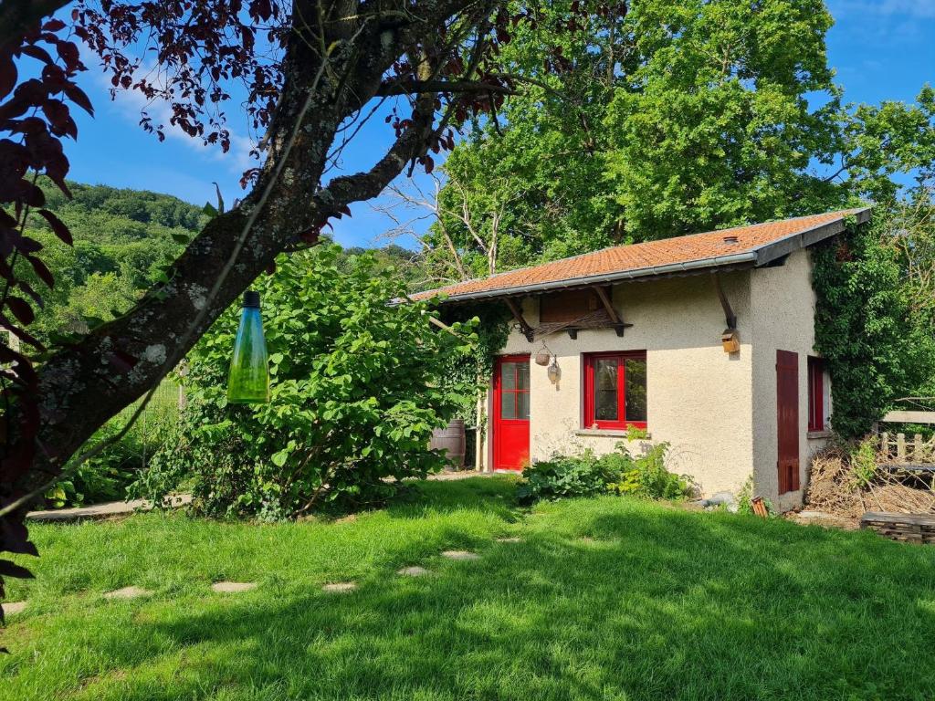 uma pequena casa com uma porta vermelha num quintal em Gîte Lagney, 1 pièce, 2 personnes - FR-1-584-291 