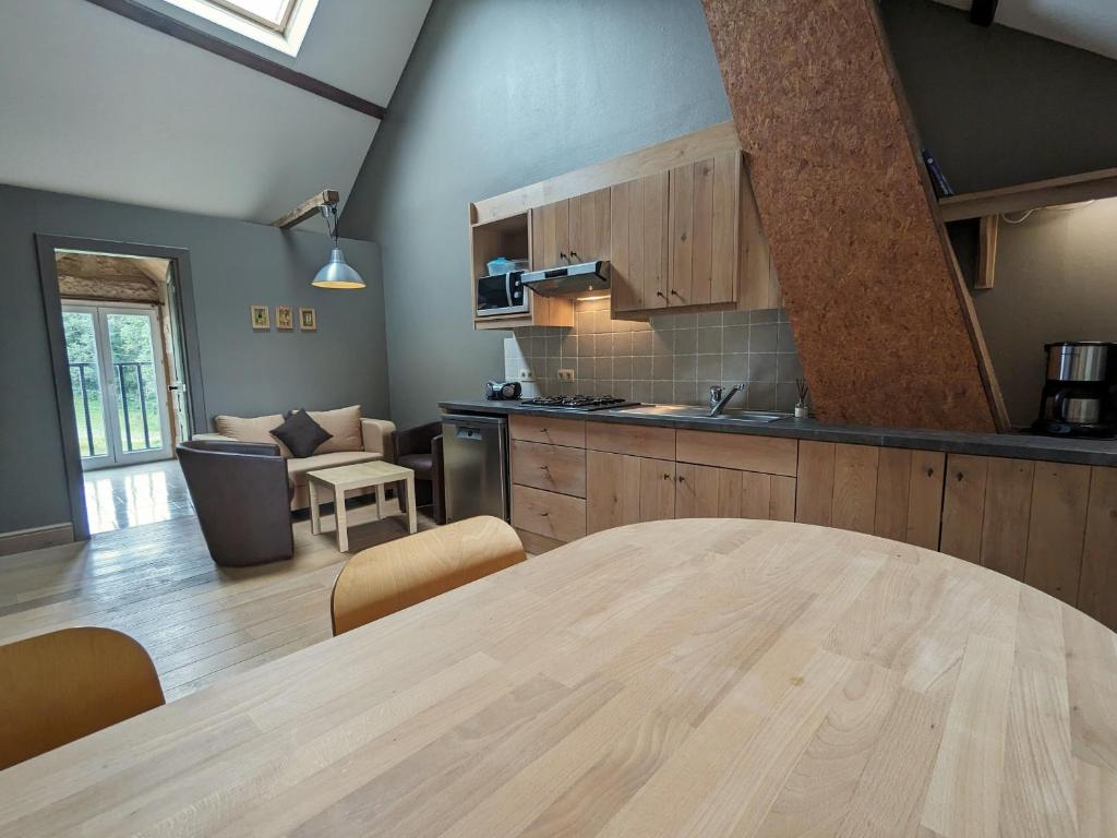 een keuken en een woonkamer met een grote houten tafel bij Gîte Communauté de communes Brenne - Val de Creuse-Ciron, 3 pièces, 2 personnes - FR-1-591-546 in Ciron