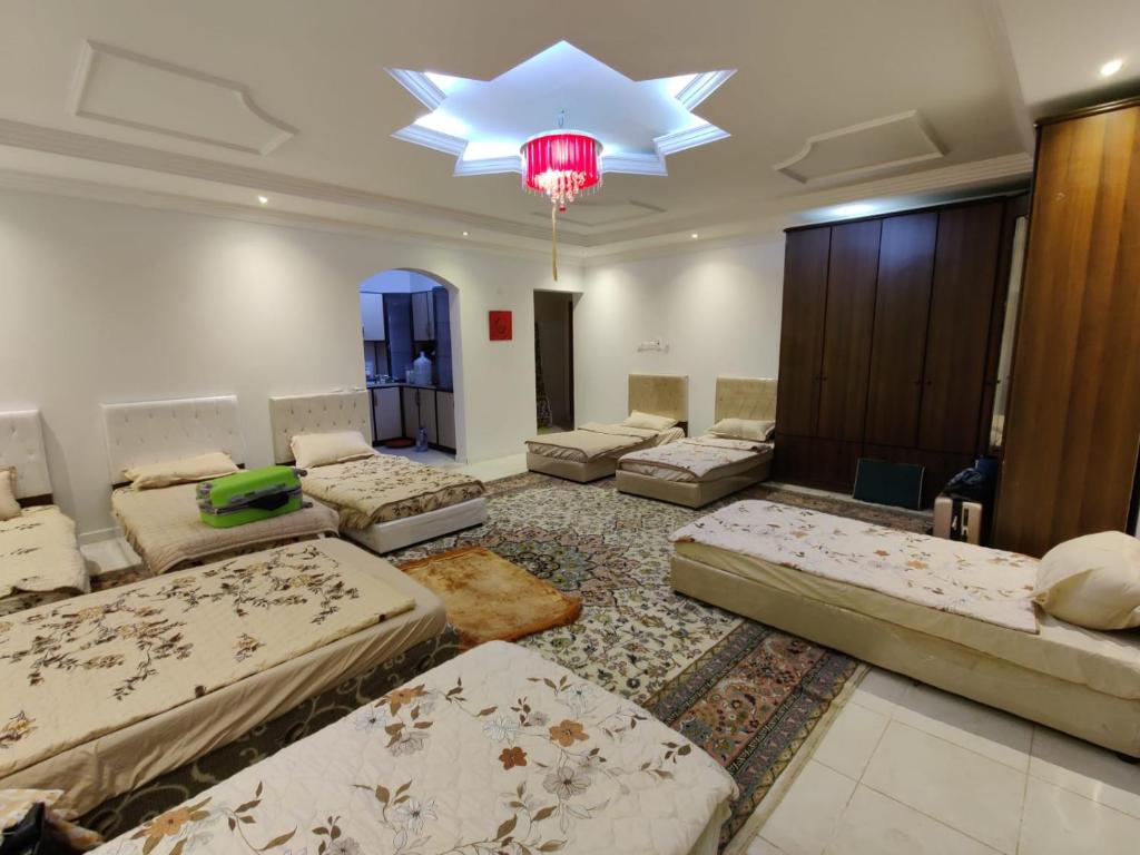 a large room with many beds and a chandelier at Fatih Hostel for Males in ‘Urwah