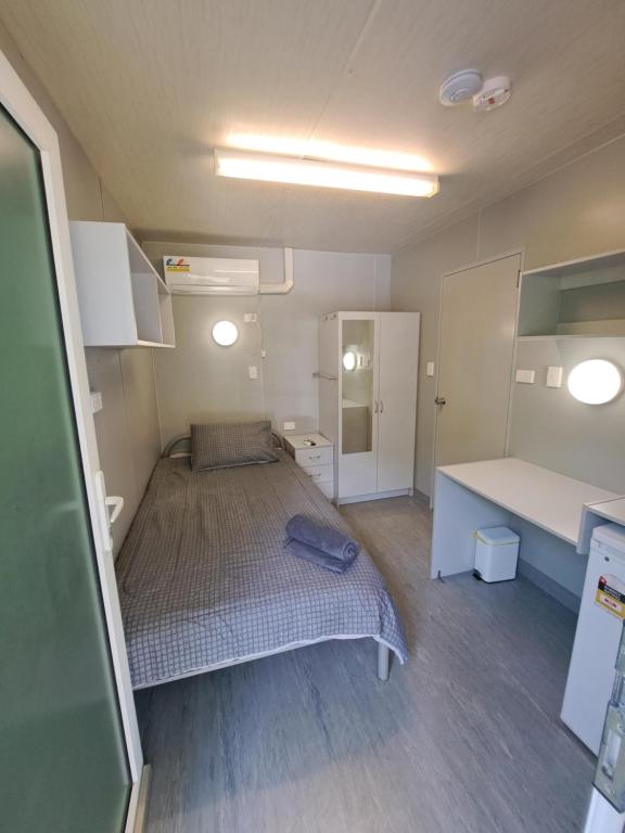 Habitación pequeña con cama y escritorio. en Cooktown Fishing Haven, en Cooktown
