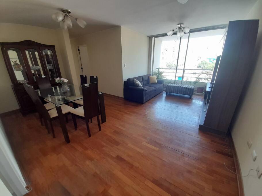 sala de estar con mesa, sillas y sofá en Encantador apartamento con excelente ubicación, en Lima
