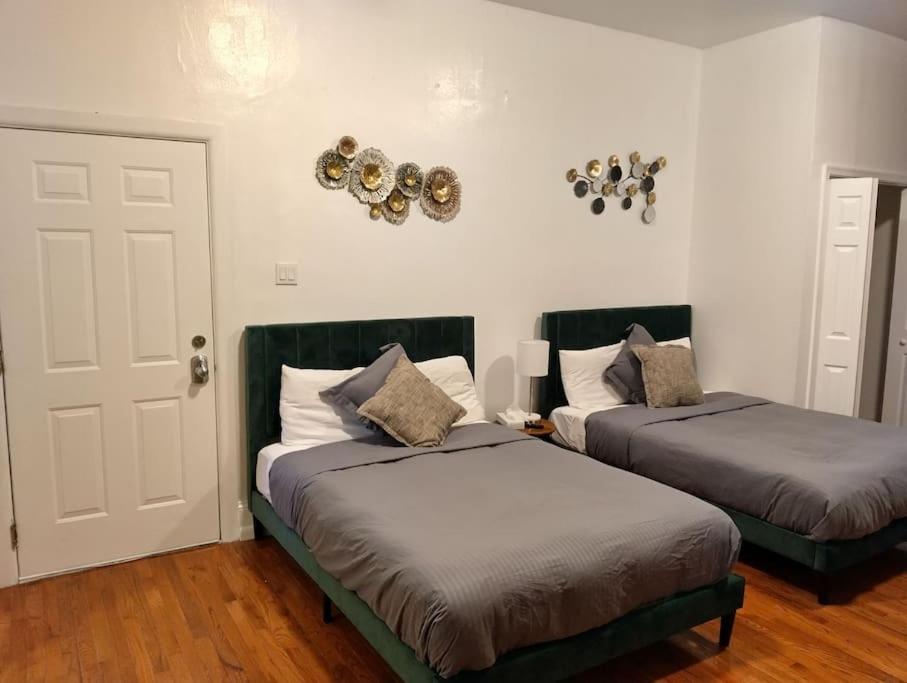 a bedroom with two beds and a white door at New Gardenroom 2 Beds (apt4) in Philadelphia