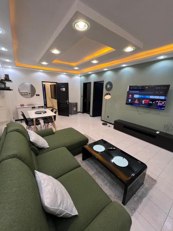 uma sala de estar com um sofá verde e uma televisão de ecrã plano em Le cocon by sdm em Dakar