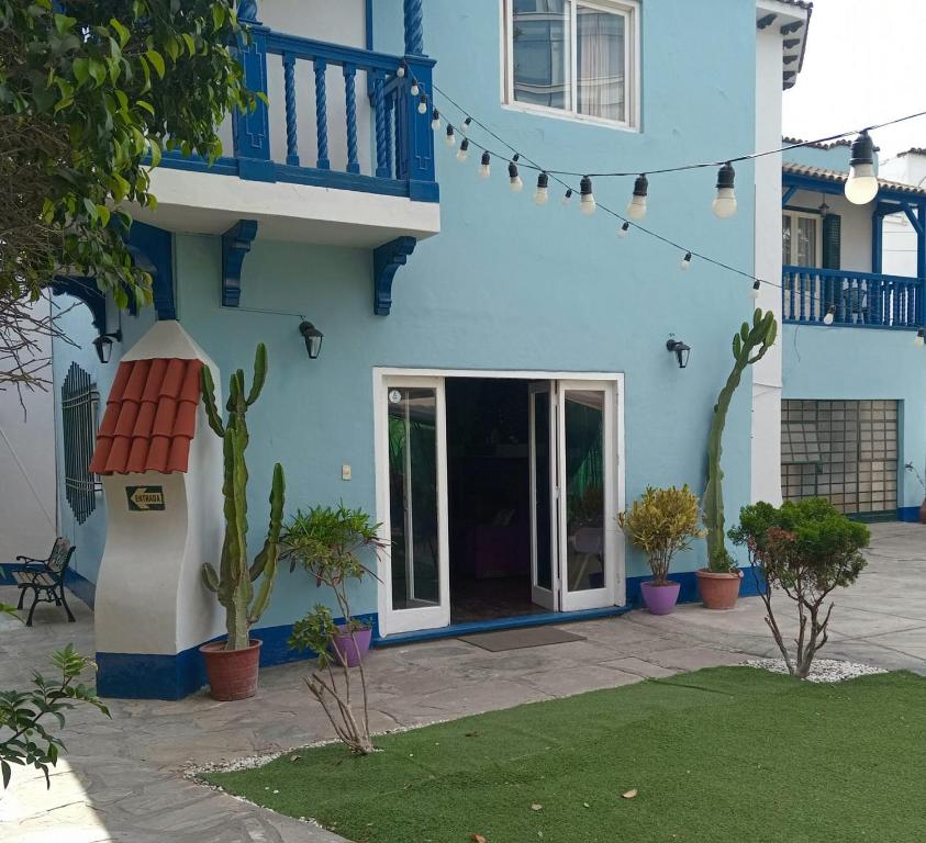 ein blaues Gebäude mit Pflanzen davor in der Unterkunft The Place Miraflores in Lima