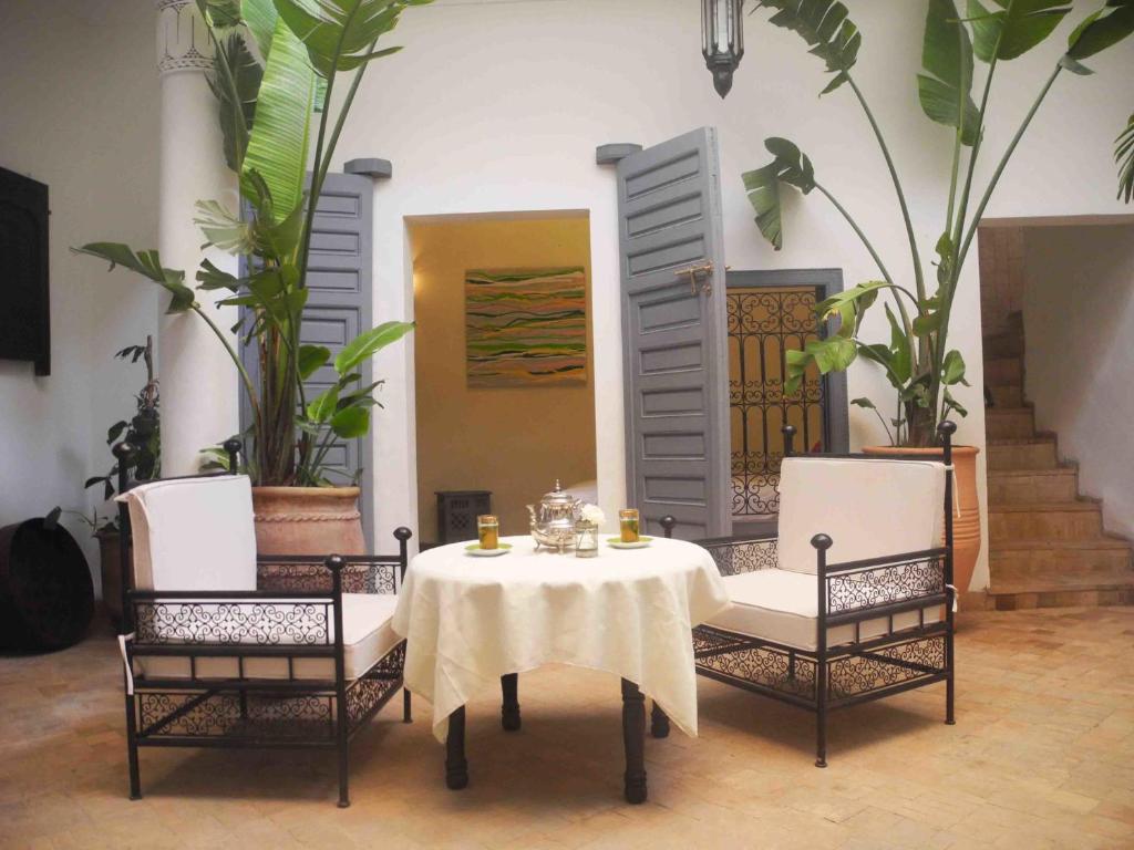un tavolo con due sedie e un tavolo con una tovaglia bianca di Riad Linda a Marrakech