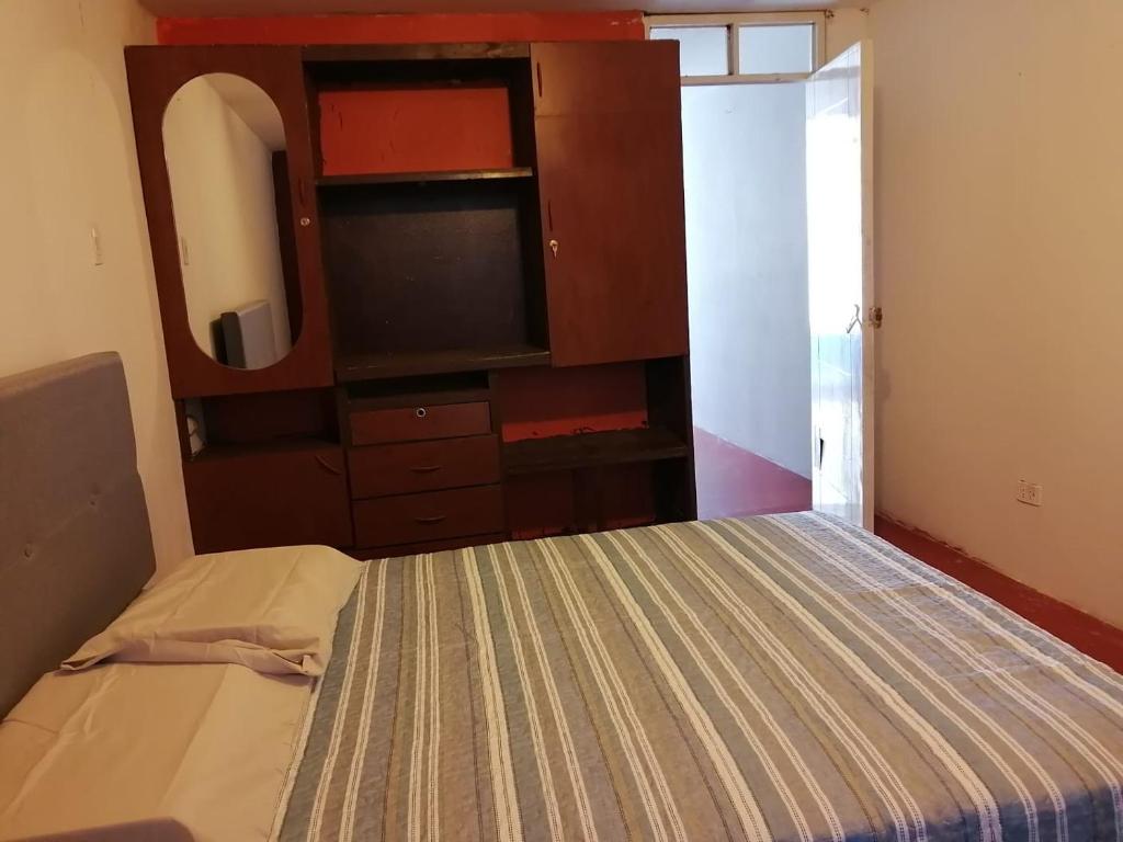 sypialnia z łóżkiem z komodą i telewizorem w obiekcie Habitación Privada con baño privado w mieście Zamacola