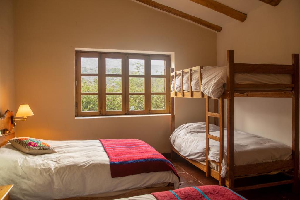 a bedroom with two bunk beds and a window at Almawasi Lodge in Yungay