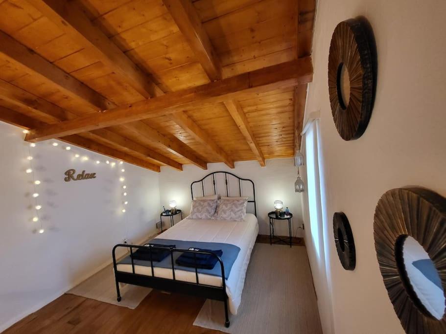 1 dormitorio con cama y techo de madera en Refúgio de Velada - Nisa, en Nisa