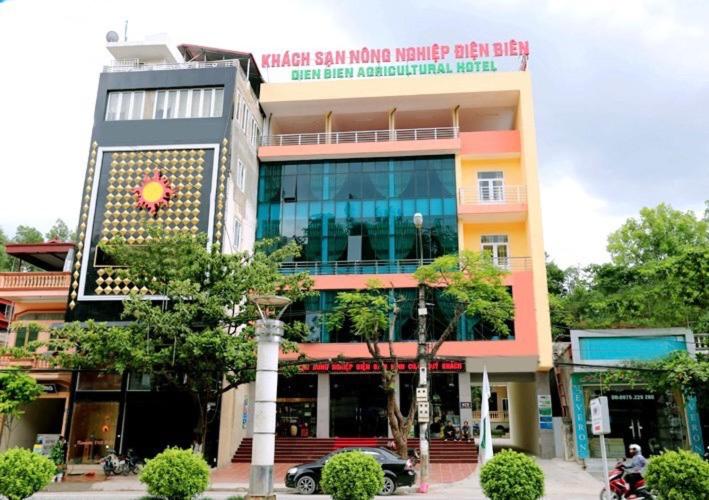 un edificio con un coche aparcado delante de él en Agri Hotel Điện Biên Phủ - by Bay Luxury, en Diện Biên Phủ