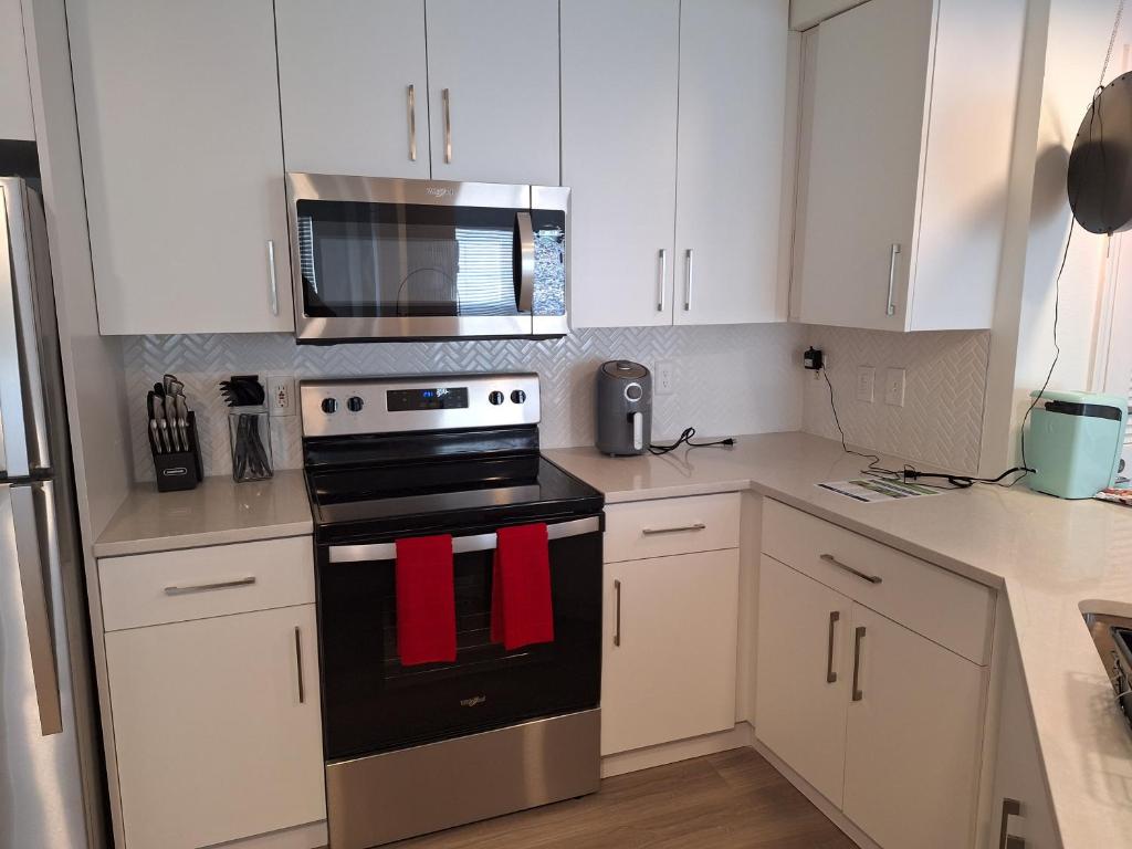 cocina con armarios blancos y fogones con toallas rojas en Briarcliff Oasis, en Atlanta