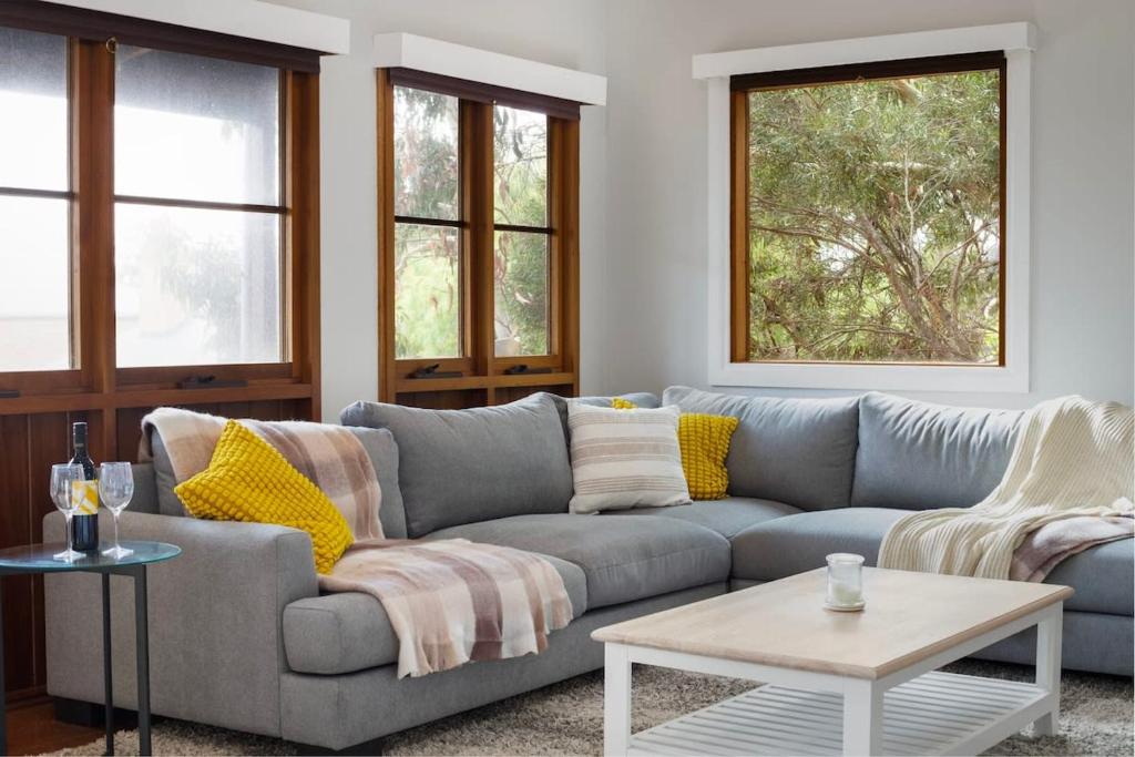 a living room with a couch and a table at Strong Farmers Cottage Willunga in Willunga