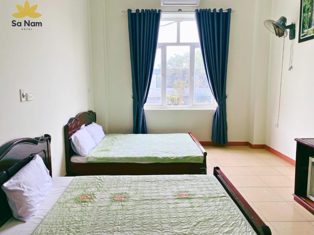 2 camas en una habitación con ventana en Khách sạn Sa Nam Cửa Lò, en Thương Xà (2)