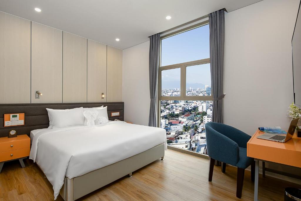 um quarto com uma cama, uma secretária e uma janela em GRAND CITIVIEW DANANG em Da Nang