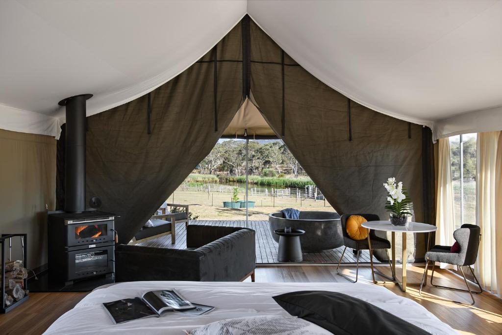a room with a tent with a bed and a fireplace at Serenità Stanthorpe in Severnlea