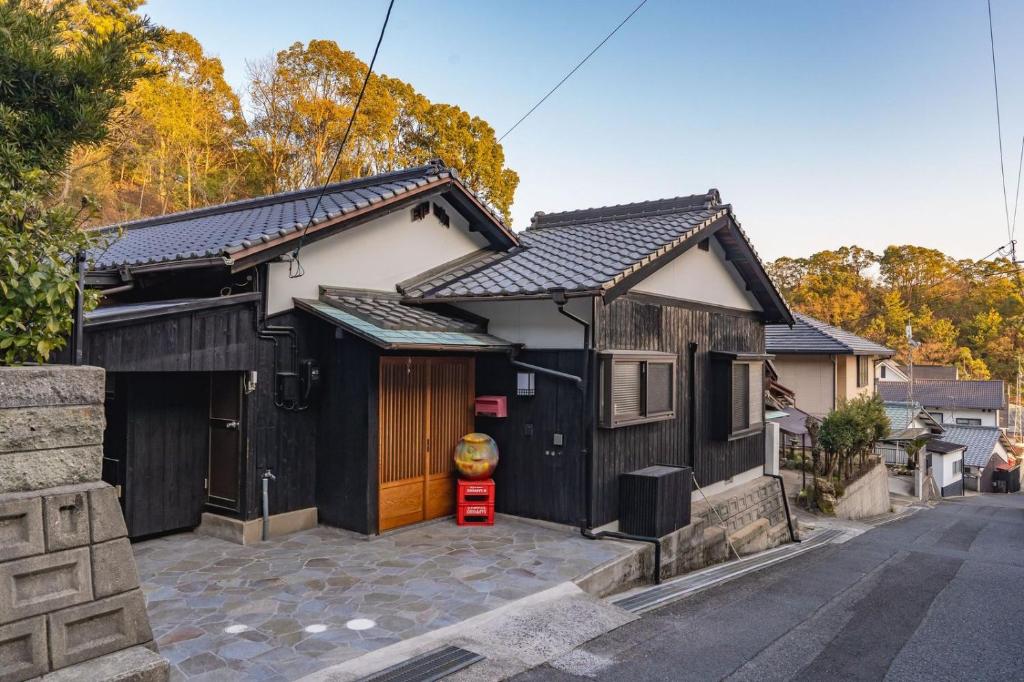 a black and white house with a garage at Naoshima Juju Art House　直島ジュジュアートハウス in Naoshima
