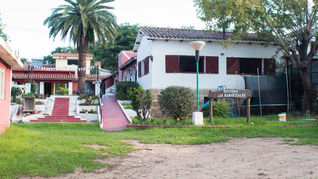 un panneau de rue devant un bâtiment blanc dans l'établissement Los Manantiales, à Tanti