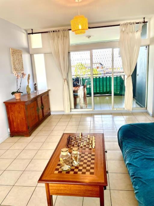 ein Wohnzimmer mit einem Schachspiel auf dem Tisch in der Unterkunft Très Spacieux T2 hyper centre in Kourou