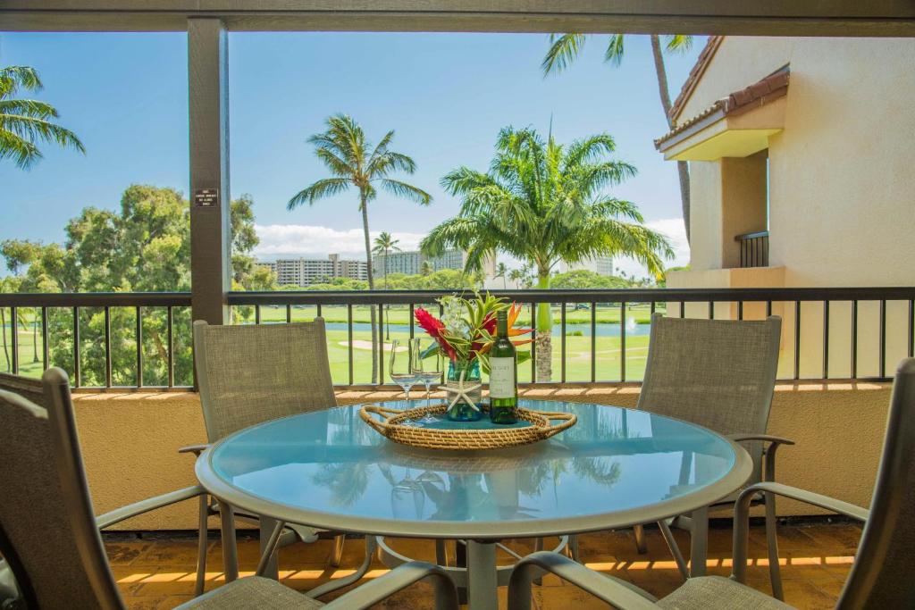 a table with a vase of flowers on a balcony at Kaanapali Royal B303 in Lahaina