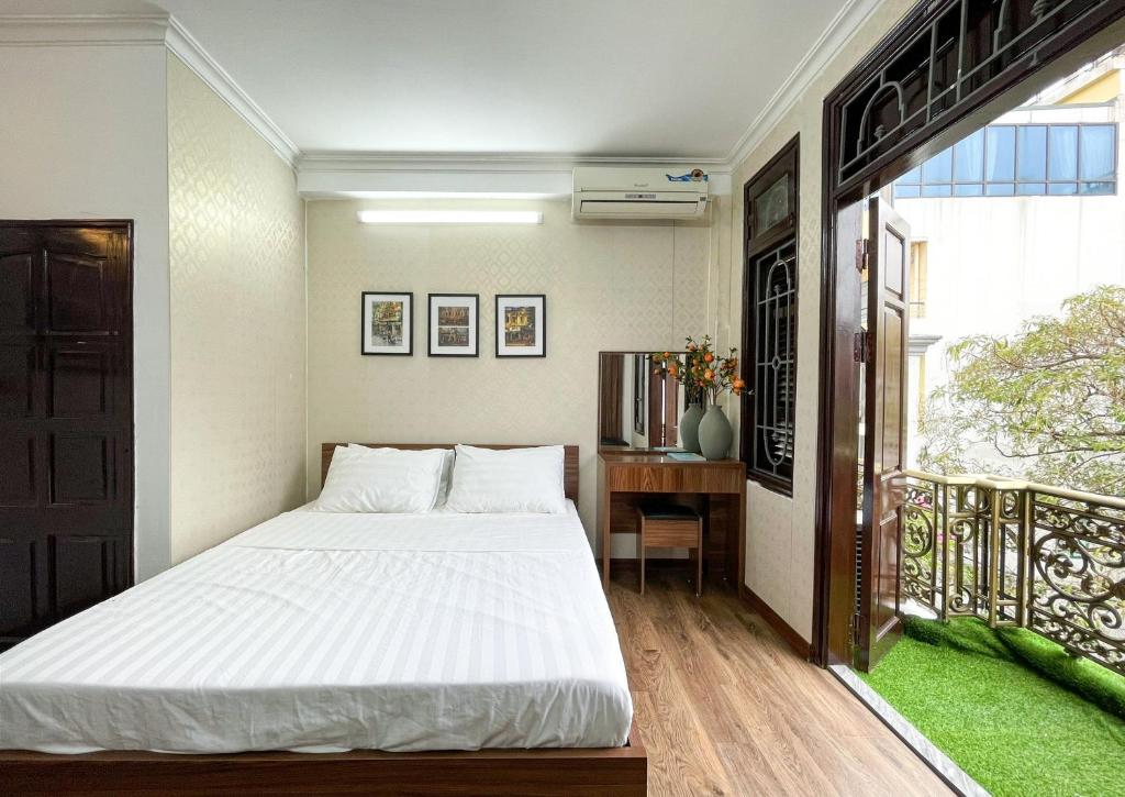 um quarto com uma cama branca e uma varanda em Hanoi Oriental Viewl Hotel em Hanói