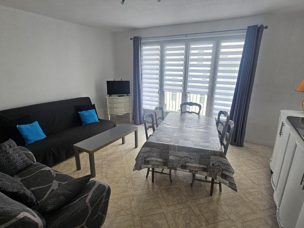 un salon avec une table et un canapé dans l'établissement Spacieux appartement 2 chambres à 450m de la plage et près du centre de Royan - FR-1-71-75, à Royan