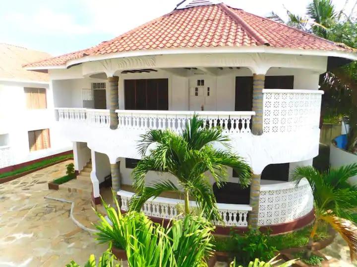 a large white house with a red roof at Bedroom Diani Beach in Diani Beach
