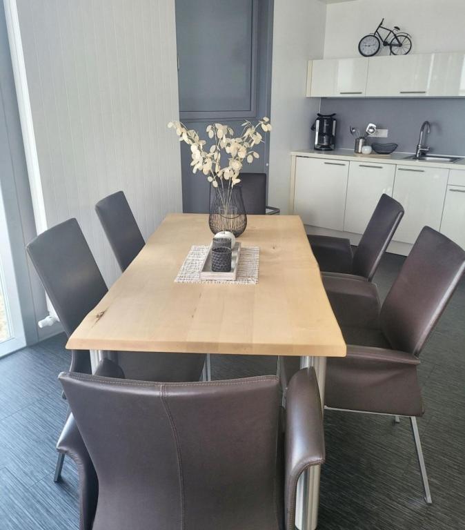a dining room table with chairs and a vase of flowers at Appartment Seeblick 4 1OG Grundbelegung 4 Pers in Elsterheide
