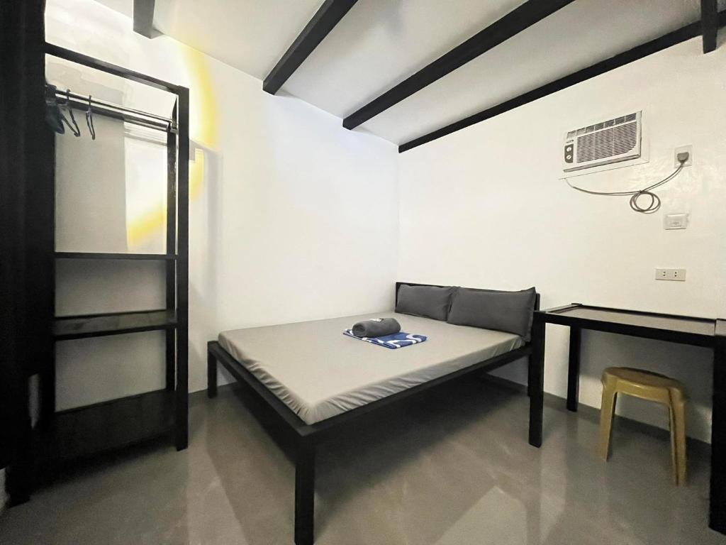 Cette chambre comprend un lit, une table et un bureau. dans l'établissement Shawe pension house, à San Remigio
